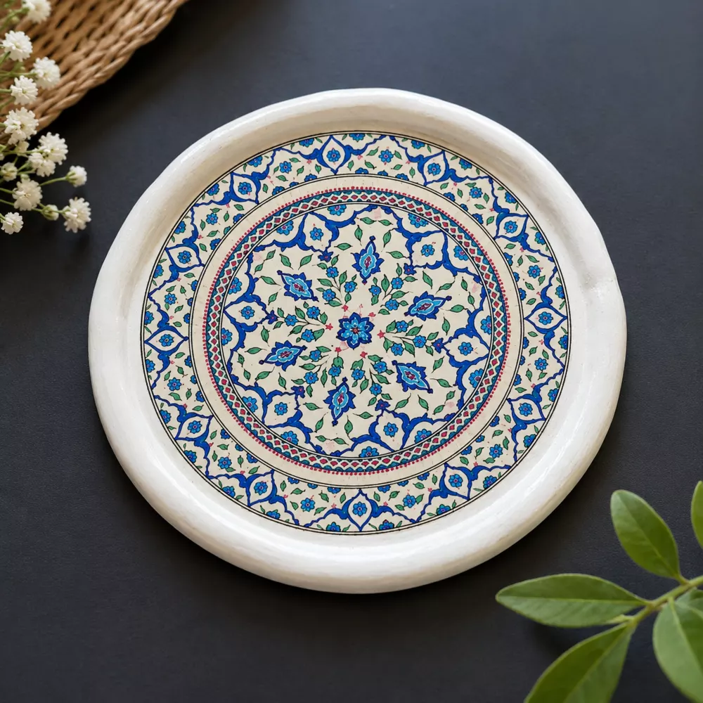 Blue floral mandala coaster on a dark background.