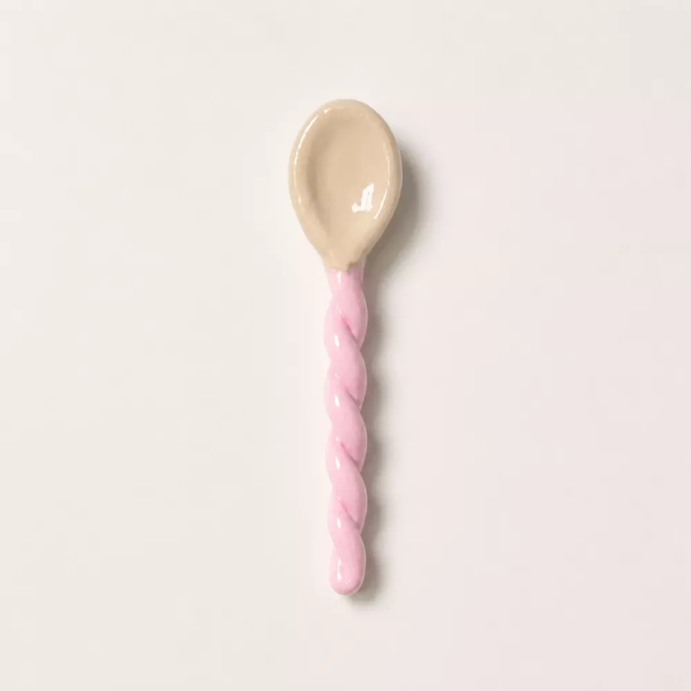 Pink handcrafted ceramic spoon with a twisted handle.