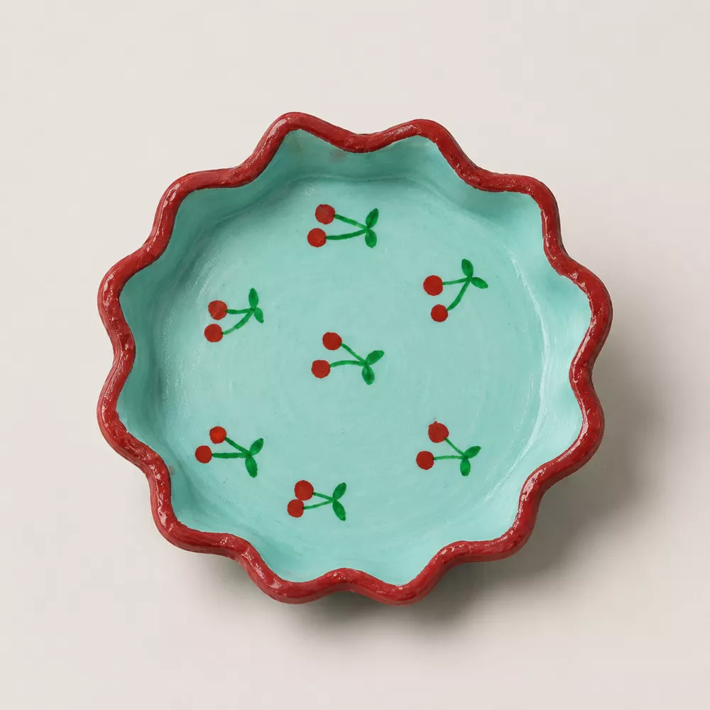 Aqua scallop trinket tray with cherry artwork and a red border.